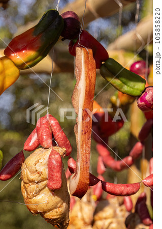 strip of bacon roasting hanging on outdoor barbecue strip of bacon roasting hanging on outdoor barbecue 105858220