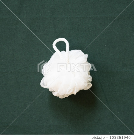Bathroom white shower towel puff isolated on green fabric background. top view, copy space Bathroom white shower towel puff isolated on green fabric background. top view, copy space 105861940