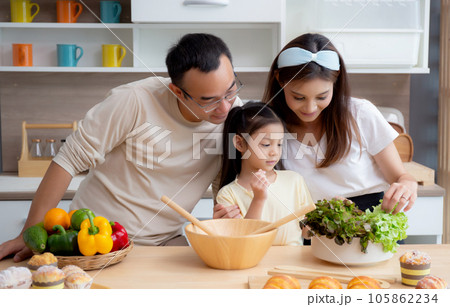 Happiness asian family with father and mother and daughter preparing cooking salad vegetable food. Happiness asian family with father and mother and daughter preparing cooking salad vegetable food. 105862234
