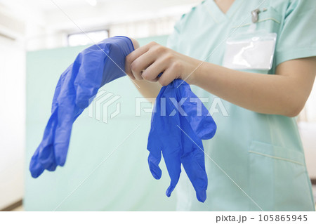 病院でゴム手袋をする若い女性看護師手元 病院でゴム手袋をする若い女性看護師手元 105865945