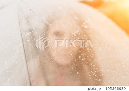 Woman rain umbrella. Happy woman portrait wearing a raincoat with transparent umbrella outdoors on rainy day in park near sea. Girl on the nature on rainy overcast day. Woman rain umbrella. Happy woman portrait wearing a raincoat with transparent umbrella outdoors on rainy day in park near sea. Girl on the nature on rainy overcast day. 105866020