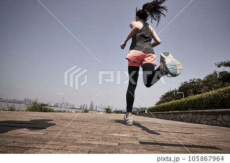 young asian adult woman running jogging outdoors, rear and low angle view young asian adult woman running jogging outdoors, rear and low angle view 105867964