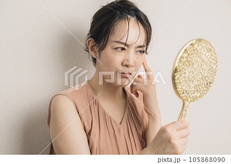 鏡を見て悩む40代の女性 105868090