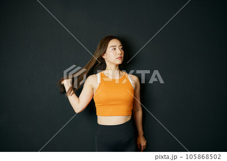 髪をかき分けるスポーツウェア姿の女性 髪をかき分けるスポーツウェア姿の女性 105868502