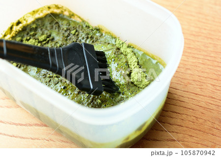 容器に入った毛染めのヘナの粉をブラシで混ぜる 105870942