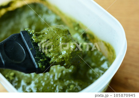 容器に入った毛染めのヘナの粉をブラシで混ぜる 105870945