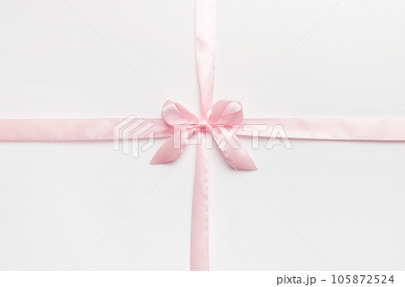 Top view of purple ribbon rolled and pink bow isolated on colored background. Flat lay with copy space Top view of purple ribbon rolled and pink bow isolated on colored background. Flat lay with copy space 105872524
