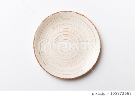Top view of isolated of colored background empty round beige plate for food. Empty dish with space for your design Top view of isolated of colored background empty round beige plate for food. Empty dish with space for your design 105872663