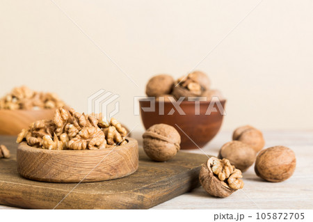 Fresh healthy walnuts in bowl on colored table background. Top view Healthy eating bertholletia concept. Super foods 105872705