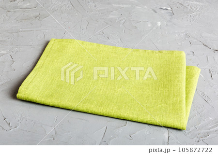 top view with green kitchen napkin isolated on table background. Folded cloth for mockup with copy space, Flat lay. Minimal style top view with green kitchen napkin isolated on table background. Folded cloth for mockup with copy space, Flat lay. Minimal style 105872722