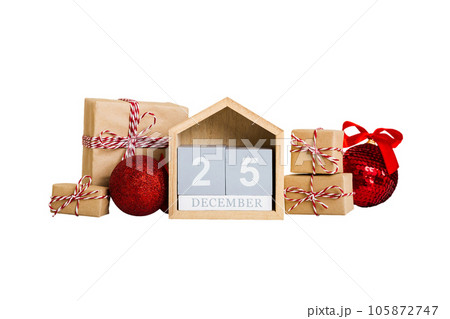 25 december. Christmas composition on colored background with a wooden calendar, with a gift box, toys, bauble copy space 105872747