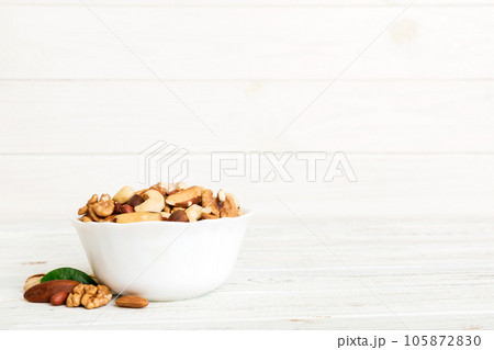 mixed nuts in bowl. Mix of various nuts on colored background. pistachios, cashews, walnuts, hazelnuts, peanuts and brazil nuts mixed nuts in bowl. Mix of various nuts on colored background. pistachios, cashews, walnuts, hazelnuts, peanuts and brazil nuts 105872830