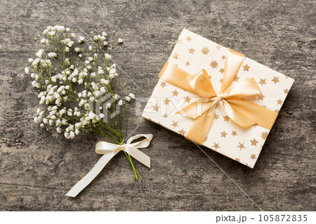Gift or present box and flower gypsophila on light table top view. Greeting card. Flat lay style with copy space 105872835
