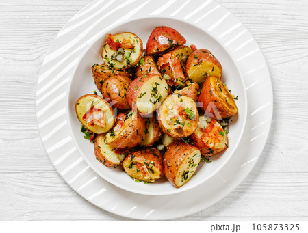 Herbs Garlic Potatoes in white bowl, top view Herbs Garlic Potatoes in white bowl, top view 105873325