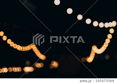Decorative outdoor string lights at night time, Defocused Background, night city life backdrop, party time with Yellow bokeh balls Decorative outdoor string lights at night time, Defocused Background, night city life backdrop, party time with Yellow bokeh balls 105873569