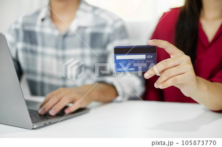E-commerce Concept. Happy couple holding credit card enjoying doing online shopping and using laptop enter their card number in-app to purchase and payment in internet store 105873770