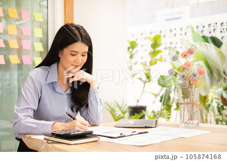 Asian businesswoman sit at their desks and calculate financial graphs showing results about their investments, plan a successful business growth process 105874168