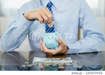 Hand putting coin into piggy bank. Saving money with coins Step into a business that is growing to be successful and save for retirement concepts Hand putting coin into piggy bank. Saving money with coins Step into a business that is growing to be successful and save for retirement concepts 105874458