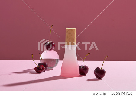 Unlabeled bottle in gradient pink color decorated with few cherries. Cherries actively nourish and soften the skin 105874710