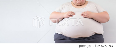 overweight young boy holding his stomach, on white background, obesity concept 105875193