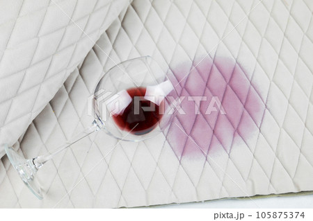 a spilled glass of wine on the tablecloth. Cleaning clothes and furniture from stains. a spilled glass of wine on the tablecloth. Cleaning clothes and furniture from stains. 105875374
