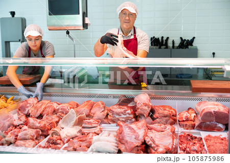 Senior butcher shop owner showing fresh raw pork ribs 105875986
