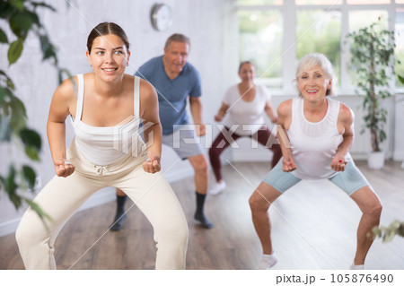 Portrait of active mature women enjoying modern energetic dancing in a group in studio 105876490