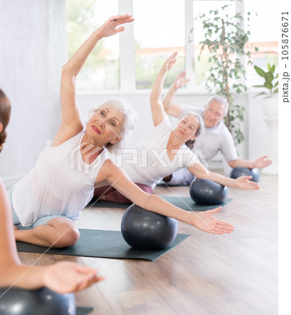 Group of elderly people doing pilates with soft ball in studio Group of elderly people doing pilates with soft ball in studio 105876671