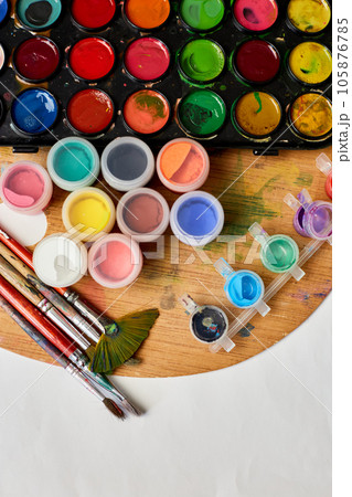 Flat lay of colorful paints, painting palette and brushes Flat lay of colorful paints, painting palette and brushes 105876785