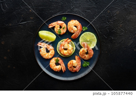 Shrimps, overhead flat lay shot on black. Cooked shrimp with lime 105877440