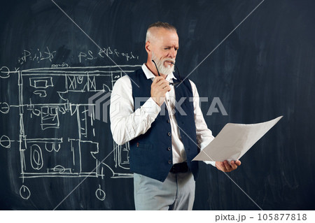Senior stylish man, professional architect looking on sketches, architectural drawings, creating new projects for building 105877818