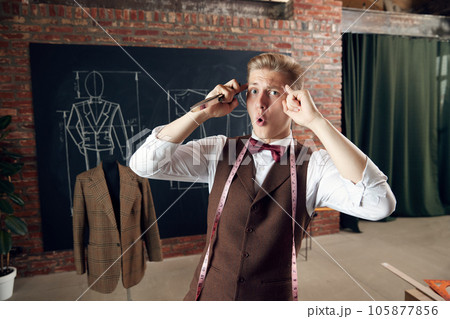Young man, fashion designer with emotional face, generating new clothing collection ideas. Creative thinking Young man, fashion designer with emotional face, generating new clothing collection ideas. Creative thinking 105877856