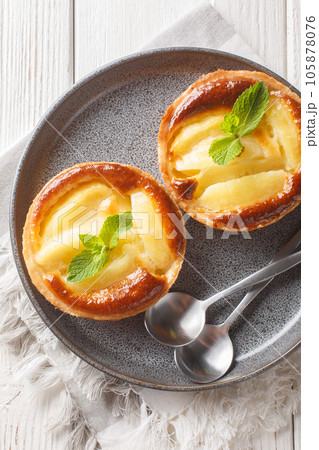Mini Apple tart with custard and mint close-up in a plate. Vertical top view 105878076