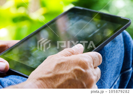 close up of man with tablet pc in park 105879282