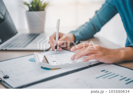 close up The business person is sitting on a calculator with a graph in the office of finance accounting concept close up The business person is sitting on a calculator with a graph in the office of finance accounting concept 105880634