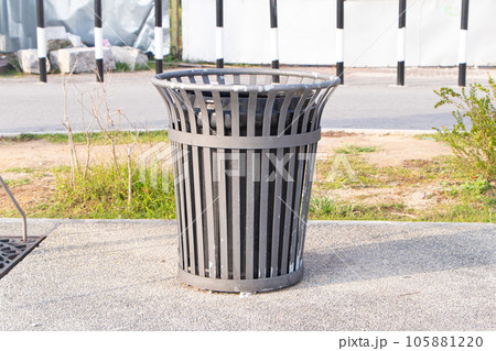 Plastic trash bin, dustbin black sphere shape road and green grass background. Waste collection equipment in the park. Global warming. Beautiful modern design. Made of good quality plastic, not rusty. 105881220
