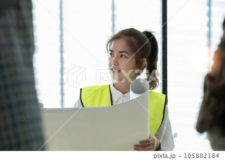 Young architect and engineer colleague workers working discussion, meeting and analyzing blueprint at construction site Young architect and engineer colleague workers working discussion, meeting and analyzing blueprint at construction site 105882184
