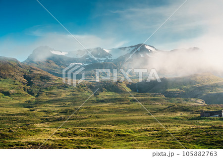 View of rural scene with fog covered mountain and tiny waterfall in summer at Iceland 105882763