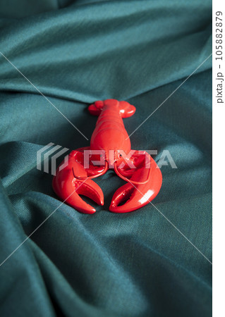 a lobster  on a green wavy fabric background 105882879