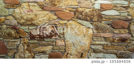 Fragment of a natural stone wall as a background or texture. The structure of the stone wall. Old castle stone wall texture Fragment of a natural stone wall as a background or texture. The structure of the stone wall. Old castle stone wall texture 105884856