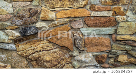 Fragment of a natural stone wall as a background or texture. The structure of the stone wall. Old castle stone wall texture 105884857
