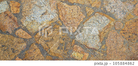 Fragment of a natural stone wall as a background or texture. The structure of the stone wall. Old castle stone wall texture 105884862