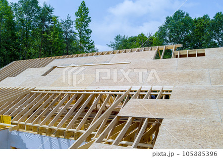 On roof plywood of wooden built home that is under construction, there in construction site 105885396