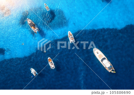Aerial view of luxury yachts and boats on blue sea at sunset Aerial view of luxury yachts and boats on blue sea at sunset 105886690