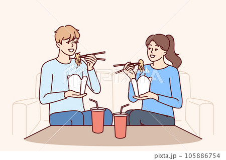 Couple eat boxed wok noodles sitting on couch using chopsticks delivered from chinese restaurant Couple eat boxed wok noodles sitting on couch using chopsticks delivered from chinese restaurant 105886754