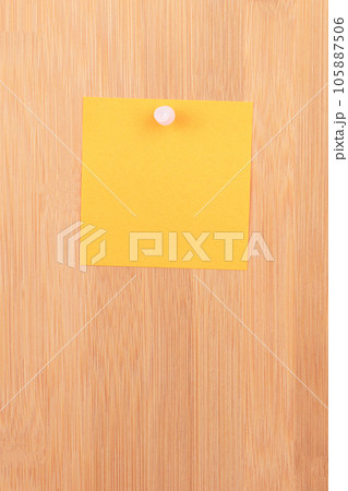 Orange Sticky Note Pinned to the Wooden Message Board 105887506