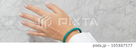 Beautiful womans hand with spring summer nail design on marble gray background 105887577