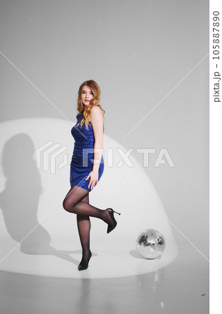 a beautiful woman in a shiny blue dress on a white background. disco ball 105887890