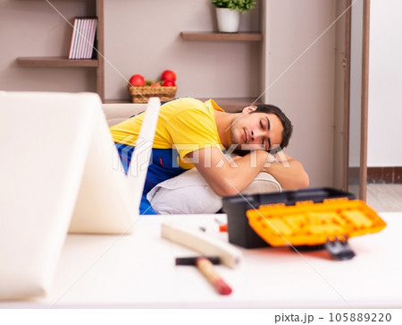 Young male contractor repairing chair at home 105889220