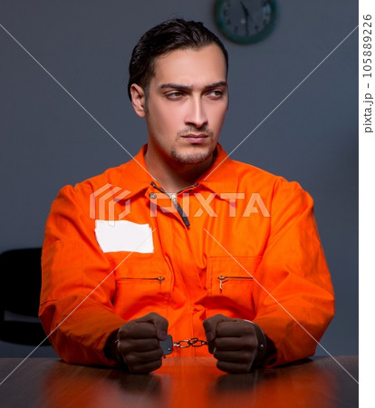 Young convict man sitting in dark room Young convict man sitting in dark room 105889226